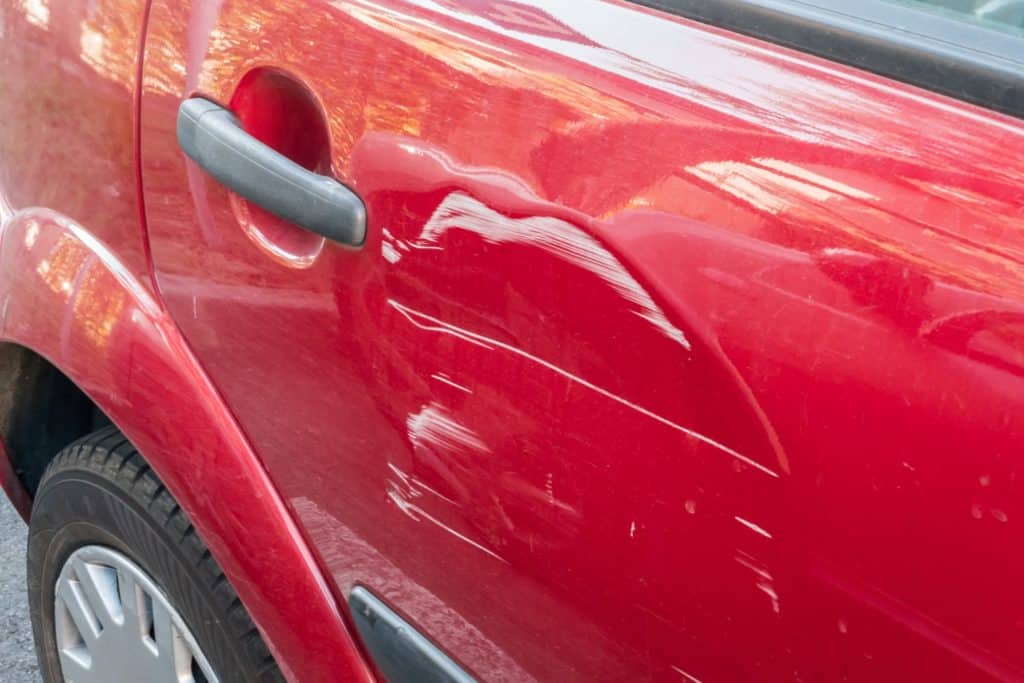 car with dented door and scratches